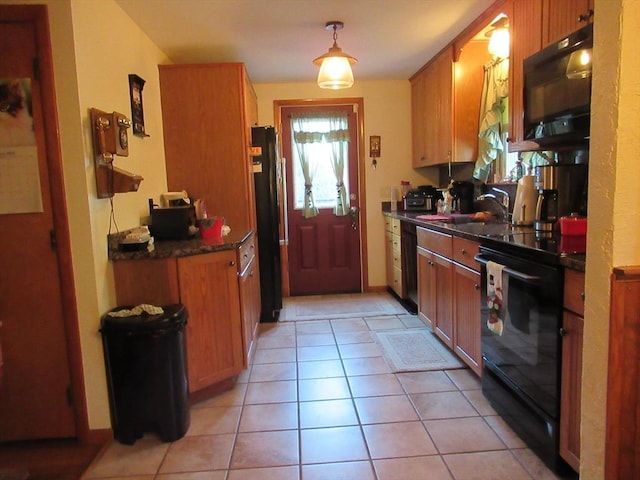 kitchen with sink, light tile patterned flooring, black appliances, and hanging light fixtures