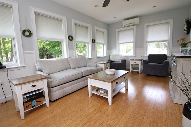 27 Summer St, Saugus, MA 01906 - living room featuring a wall mounted AC, a wainscoted wall, plenty of natural light, and a ceiling fan