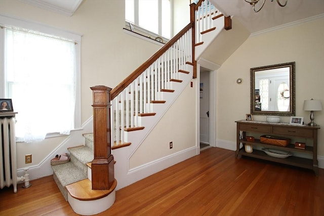 27 Summer St, Saugus, MA 01906 - stairway featuring wood finished floors, ornamental molding, baseboards, a chandelier, and radiator heating unit