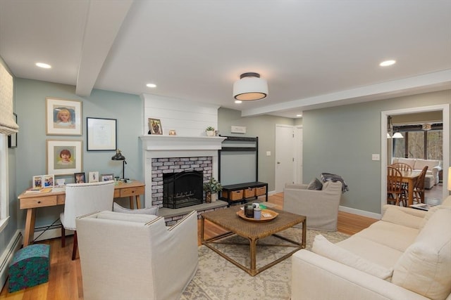 living room featuring recessed lighting, light wood-type flooring, a fireplace, and baseboards