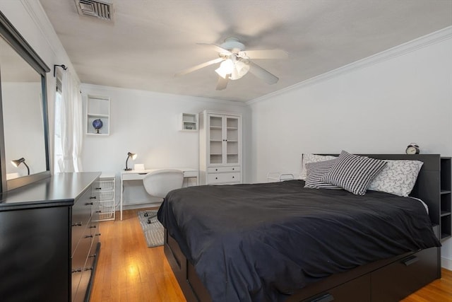 bedroom with light wood-type flooring, visible vents, crown molding, and ceiling fan