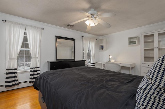 bedroom featuring ornamental molding, visible vents, multiple windows, and light wood-style flooring