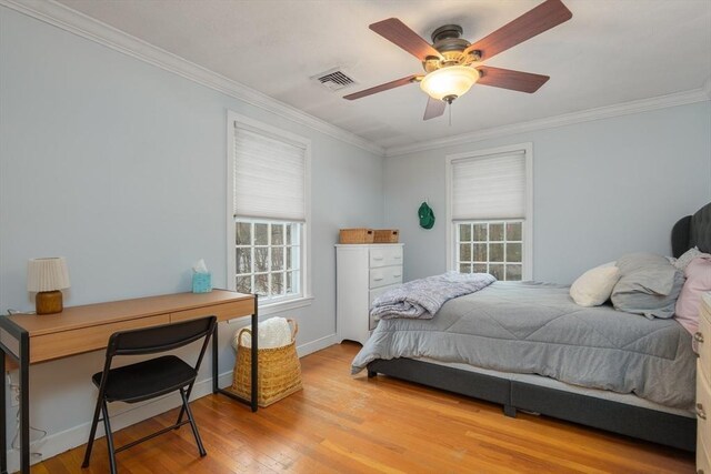 bedroom featuring baseboards, visible vents, a ceiling fan, ornamental molding, and light wood-type flooring