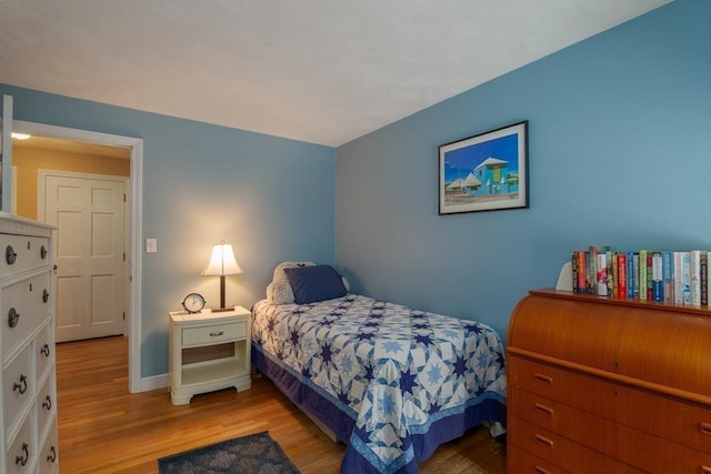 bedroom with light wood-style flooring and baseboards