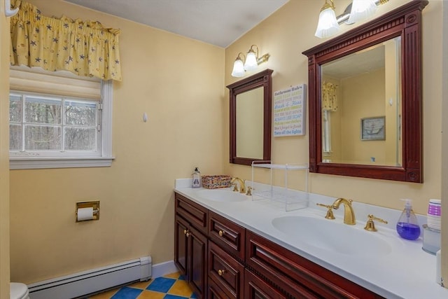 full bathroom featuring a baseboard heating unit, double vanity, a sink, and baseboards