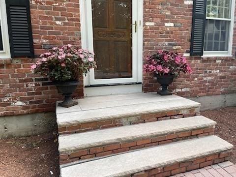 doorway to property with brick siding