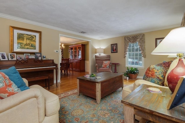 living area featuring a notable chandelier, crown molding, and wood finished floors