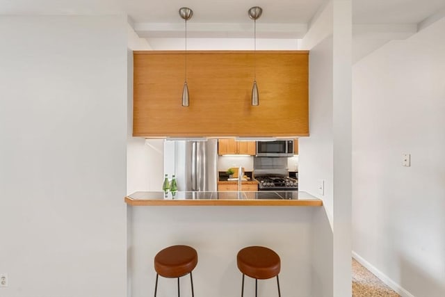 kitchen with stainless steel appliances, a breakfast bar, and kitchen peninsula