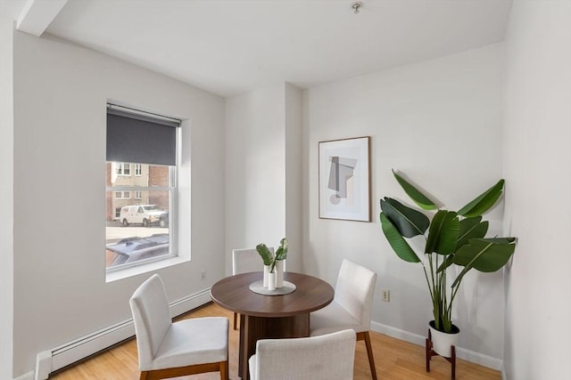 dining area featuring wood-type flooring and baseboard heating