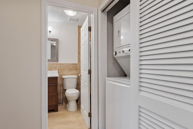5 Thomas St Unit P17, Saugus, MA 01906 - half bath with stacked washer / drying machine, vanity, tile walls, and tile patterned flooring