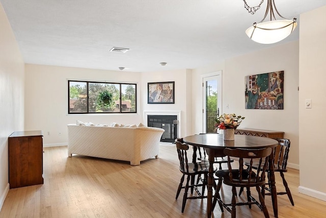 5 Thomas St Unit P17, Saugus, MA 01906 - dining space featuring healthy amount of natural light, light wood-style floors, and a fireplace with flush hearth