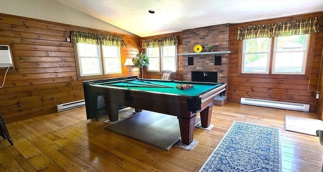 recreation room featuring a baseboard radiator, vaulted ceiling, light wood finished floors, billiards table, and wooden walls