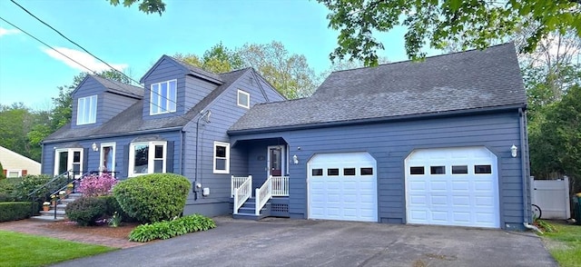 new england style home with a garage and asphalt driveway
