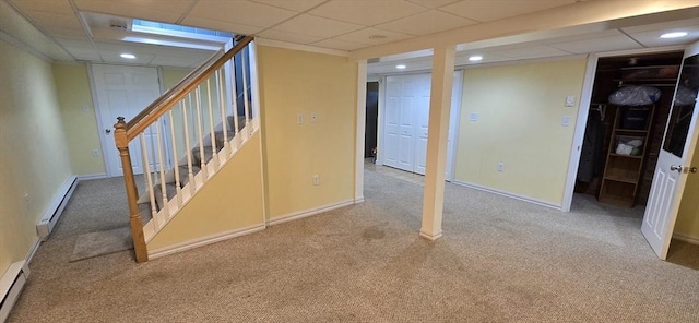 finished below grade area with a baseboard radiator, carpet, stairway, recessed lighting, and baseboards