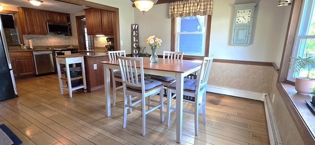 dining area with light wood finished floors and baseboards
