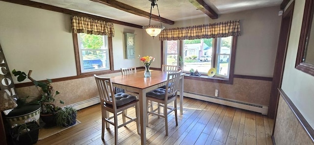 dining space featuring a baseboard radiator, beamed ceiling, hardwood / wood-style floors, and baseboards