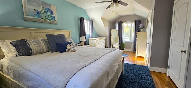 bedroom with wood finished floors, vaulted ceiling, ceiling fan, and baseboards
