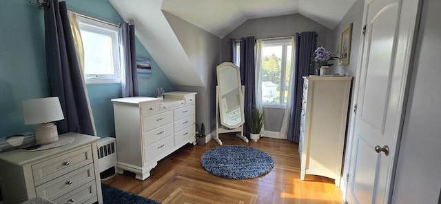 bedroom with lofted ceiling, dark wood-style flooring, and baseboards