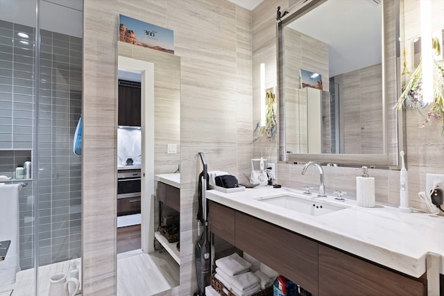 bathroom featuring vanity, tile walls, and a tile shower