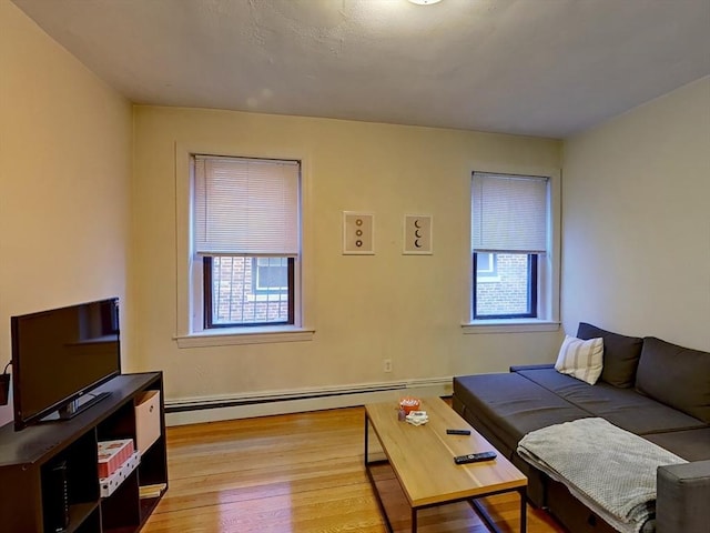 living area featuring a baseboard heating unit and light wood finished floors