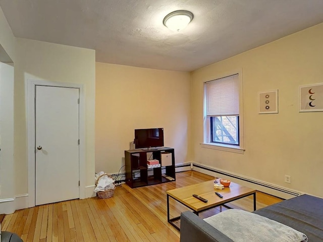 living room featuring a baseboard radiator and hardwood / wood-style flooring