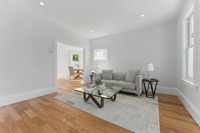 living area with light wood-style floors, baseboards, and recessed lighting