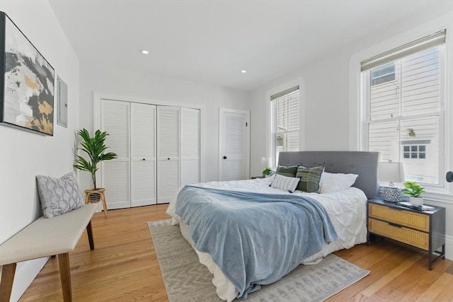 bedroom featuring light wood finished floors, recessed lighting, and a closet