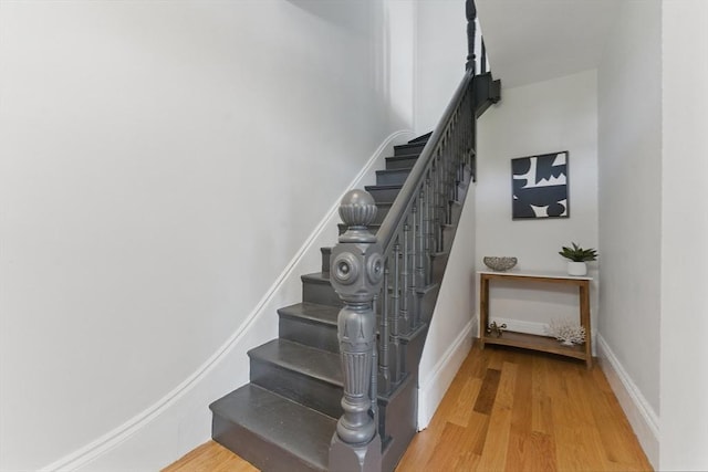 stairs featuring wood finished floors and baseboards