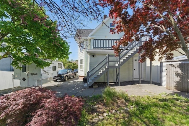 rear view of house with stairway and fence