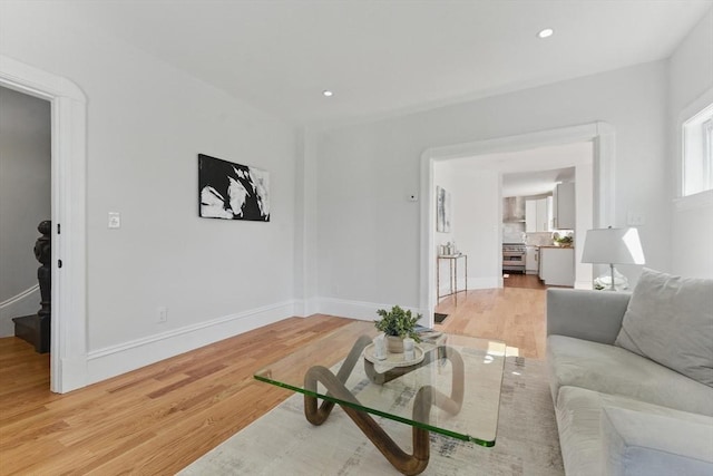 living area featuring light wood finished floors, baseboards, and recessed lighting