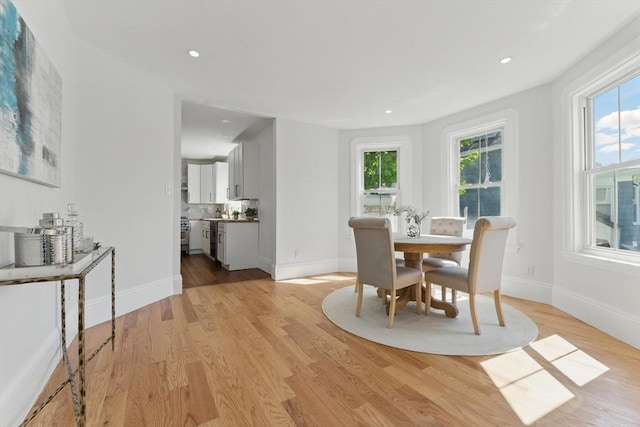 dining area featuring plenty of natural light, light wood-style flooring, baseboards, and recessed lighting