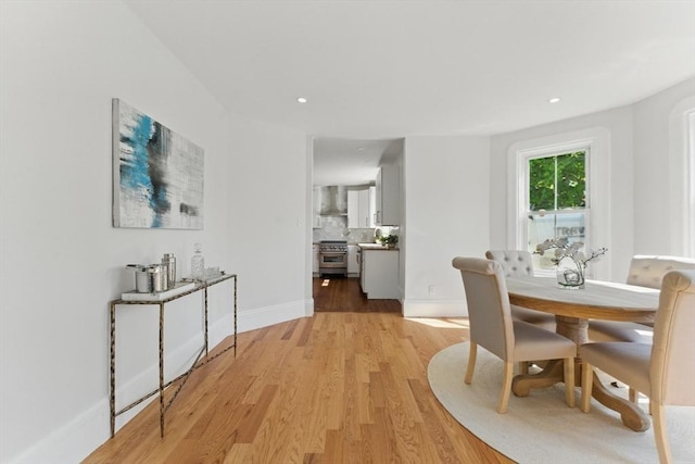 dining area with light wood finished floors, baseboards, and recessed lighting