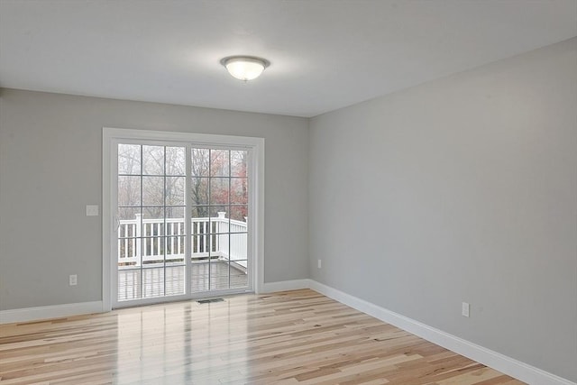 empty room featuring light wood-type flooring and baseboards