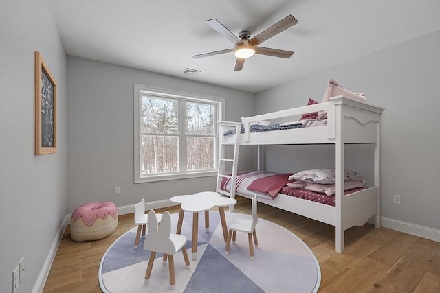bedroom featuring wood finished floors, baseboards, and a ceiling fan