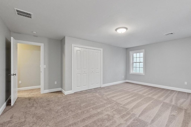 unfurnished bedroom featuring carpet flooring, baseboards, and a closet