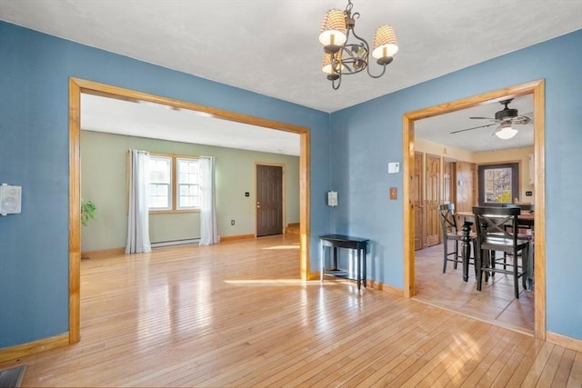 dining space featuring a baseboard radiator, ceiling fan with notable chandelier, and light hardwood / wood-style flooring