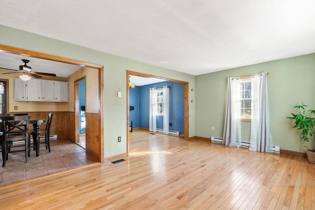 interior space with light hardwood / wood-style floors, ceiling fan, and baseboard heating