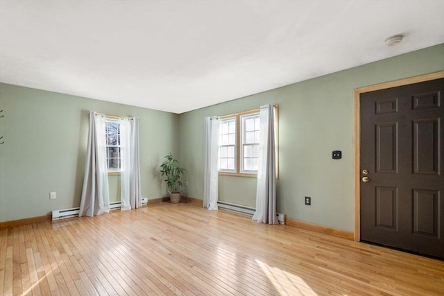 interior space featuring a baseboard heating unit and light hardwood / wood-style floors