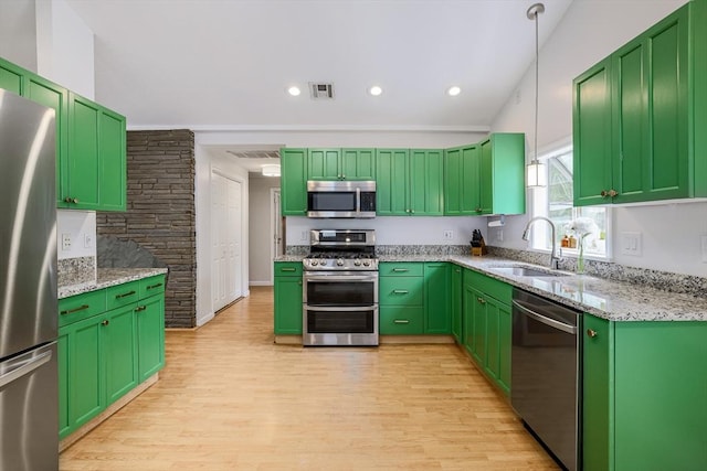 128 Clinton St, Hopkinton, MA 01748 - kitchen featuring stainless steel appliances, a sink, light wood-style floors, light stone countertops, and pendant lighting
