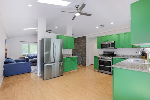 128 Clinton St, Hopkinton, MA 01748 - kitchen featuring stainless steel appliances, a sink, a skylight, green cabinets, and vaulted ceiling