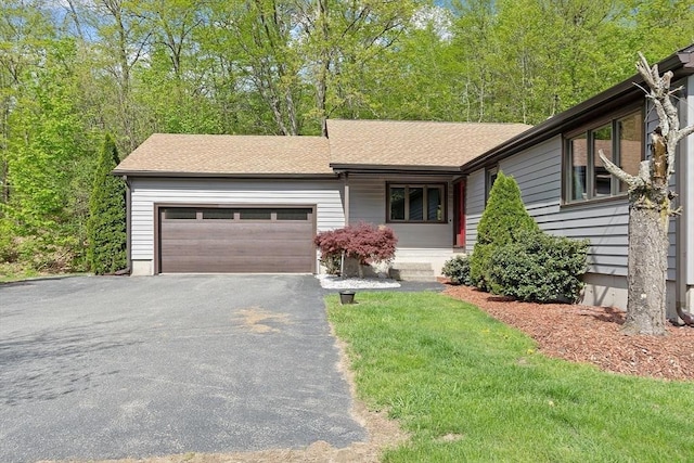 25 Williams Rd, Fitchburg, MA 01420 - ranch-style house with an attached garage, asphalt driveway, a shingled roof, and a front yard