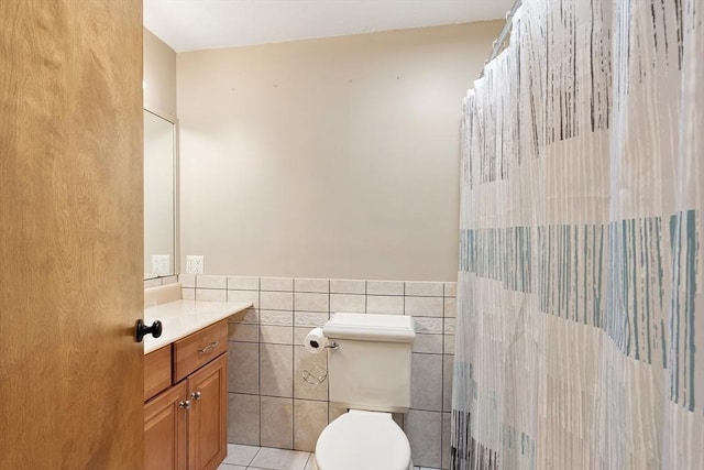 25 Williams Rd, Fitchburg, MA 01420 - bathroom featuring vanity, tile walls, toilet, a wainscoted wall, and tile patterned floors