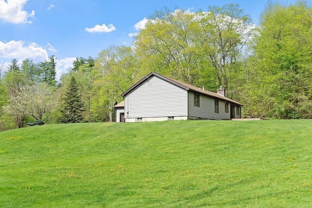 25 Williams Rd, Fitchburg, MA 01420 - view of side of home with a chimney, a lawn, a garage, and a forest view