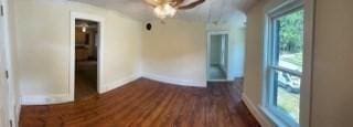 unfurnished room featuring dark wood-style flooring and baseboards