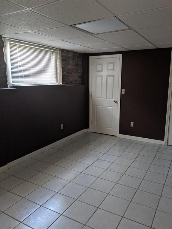 tiled spare room with a paneled ceiling