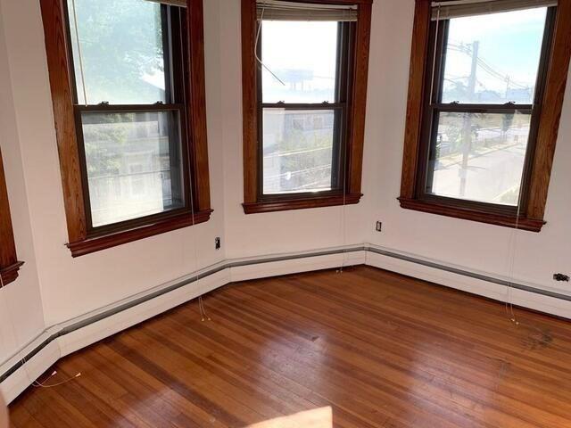 empty room featuring plenty of natural light and wood-type flooring