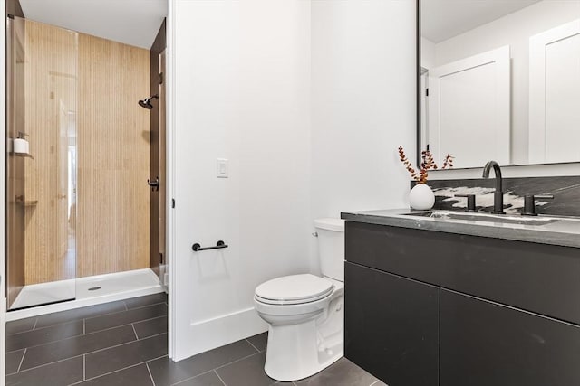 bathroom featuring toilet, tile patterned floors, walk in shower, and vanity