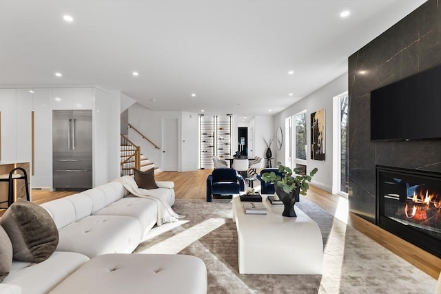 living room with a premium fireplace and light wood-type flooring