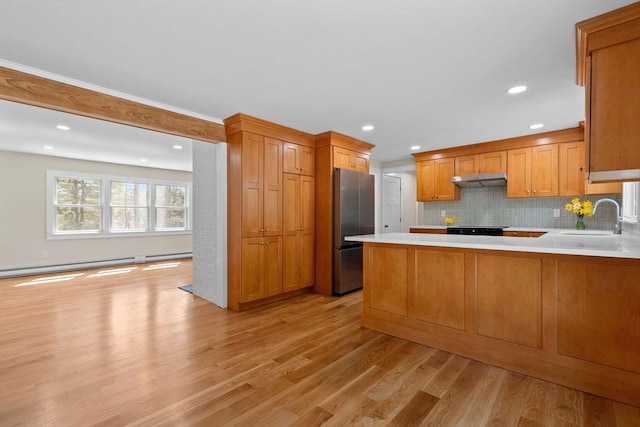 30 Grannys Ln, Orleans, MA 02653 - kitchen featuring light wood finished floors, a sink, a peninsula, light countertops, and freestanding refrigerator