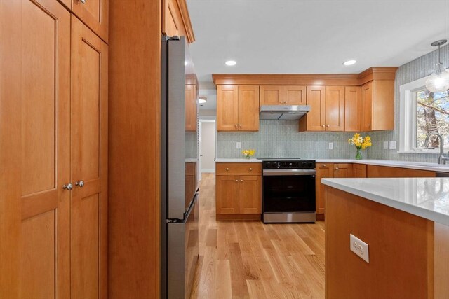 30 Grannys Ln, Orleans, MA 02653 - kitchen featuring a sink, under cabinet range hood, electric range oven, light wood-type flooring, and light countertops